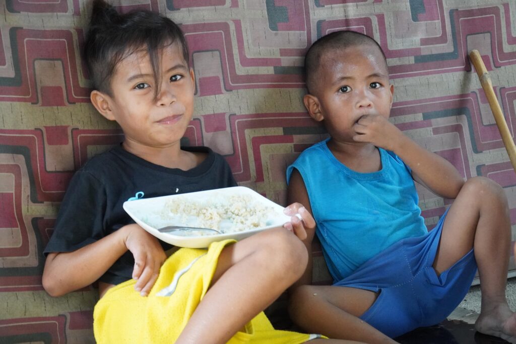 Two boys eating just rice for their lunch