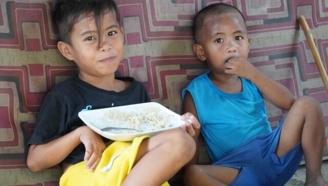 Two boys eating just rice for their lunch