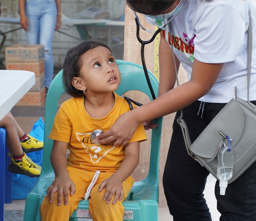 FFEC-Nutrition and Medical Page - Child being checked by a health worker- for mobile