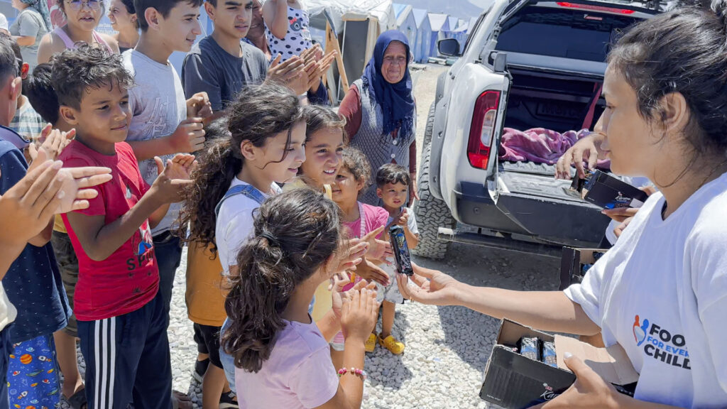 Children and their parents receiving food from volunteers in Turkey