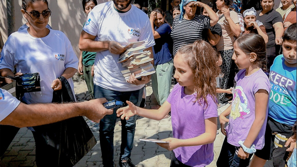 Children at an emergency tent city in Turkey receiving food from volunteers