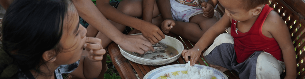 Family sharing a meager meal of fish and rice