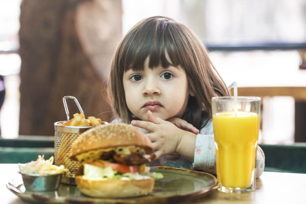 Little girl eating unhealthy junk food