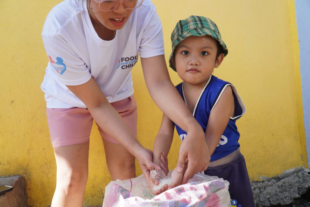 Child and volunteer with rice
