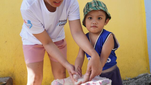 Child and volunteer with rice