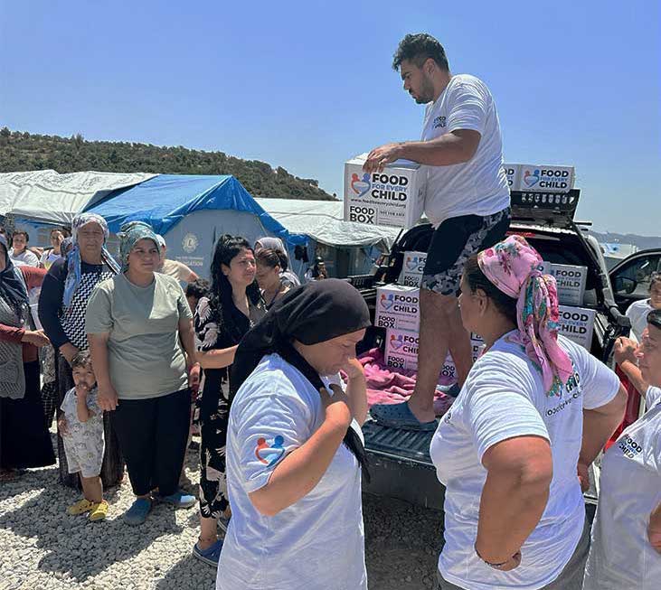 Distribution of food boxes at a tent city in Turkey following a devastating earthquake - cropped